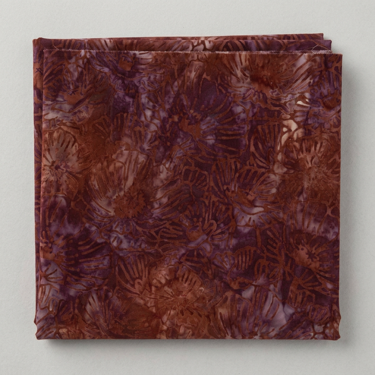 Poppy Seeds Raisin Fabric by Riley Blake Designs neatly folded on a light-gray background, with its botanical print and raw cut edge visible.
