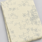 Folded Modern Background Even More Paper Eggshell Edgy fabric by Zen Chic for Moda Fabrics on a light gray background, showing scattered gray angular marks on eggshell.