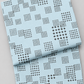 Folded Lazy Afternoon Sky Fabric by Zen Chic for Moda Fabrics on a light gray background, showing its pale blue print with scattered grids of black cross-shaped marks.