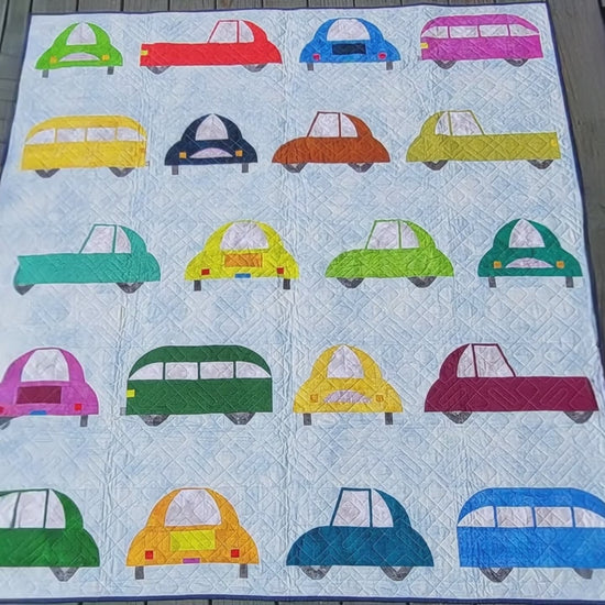Quilt with colorful car patterns on a white background