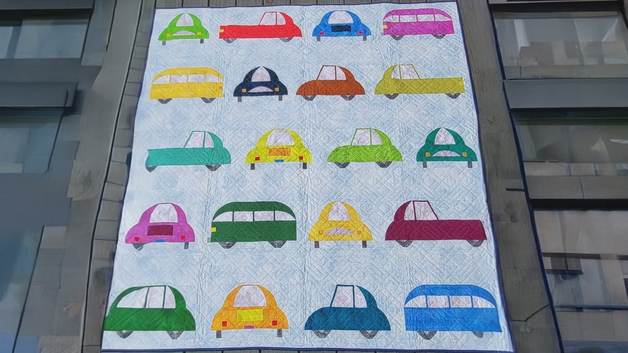 Quilt with colorful car patterns on a white background