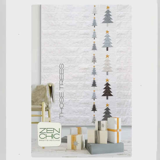 Decorative wall art with Christmas tree designs and presents on a white brick wall.