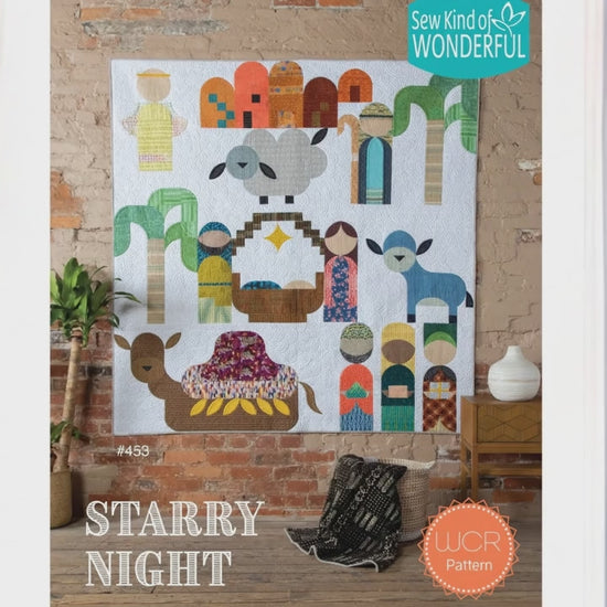 Colorful nativity scene wall quilt in a room with a window.