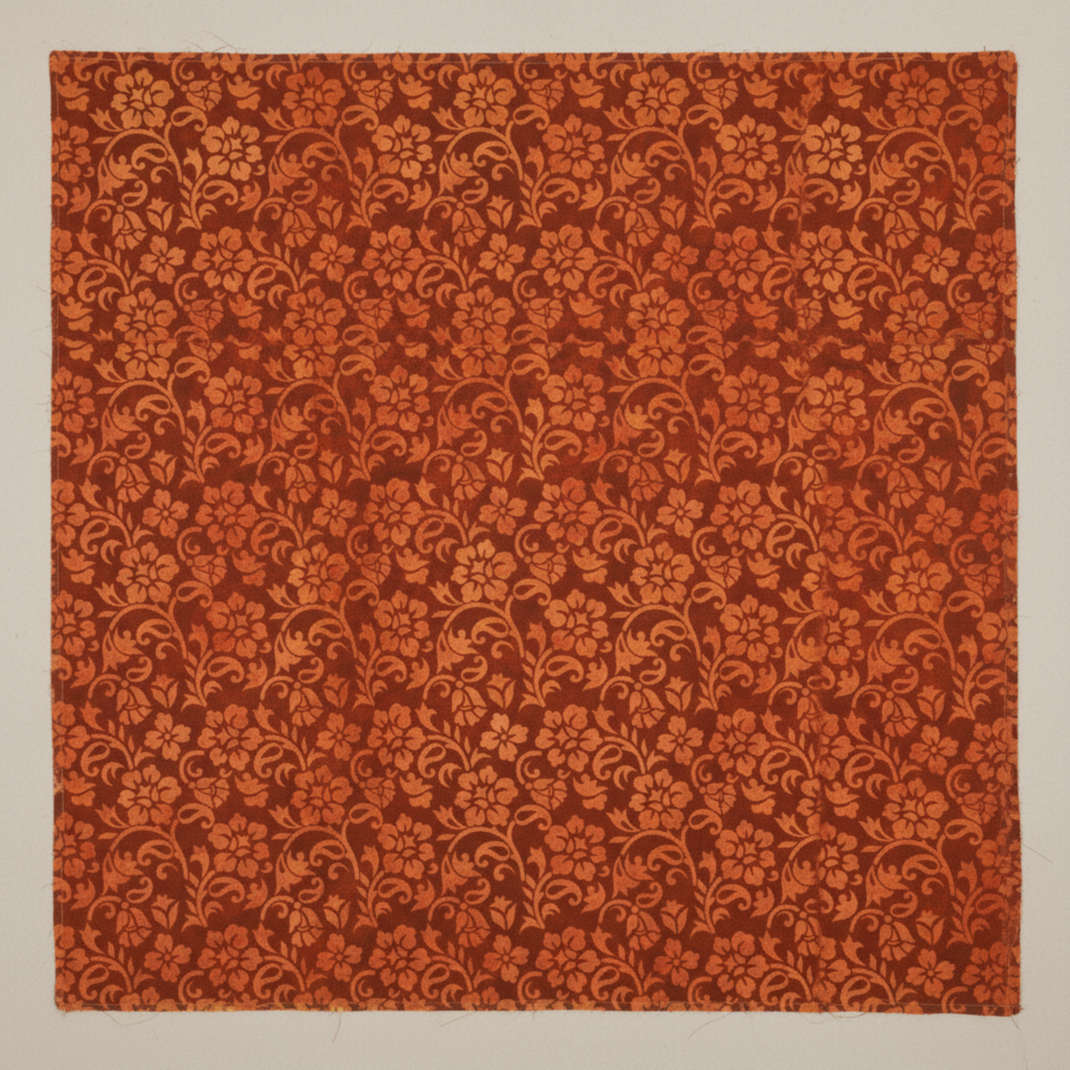 Prism II Rust Floral Vines 3 Yard Cut quilting cotton by Jason Yenter for In The Beginning Fabrics — close-up flat lay showing dense scrolling carnation-style blooms with curling vines and leaf sprays in warm orange and amber on rich deep rust-brown mottled ground, 100% cotton, 43–44" wide.