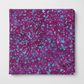 Terrazzo Purple Haze Fabric by Riley Blake Designs neatly folded on a light-gray background, showing its purple-magenta and aqua-blue pebble print.