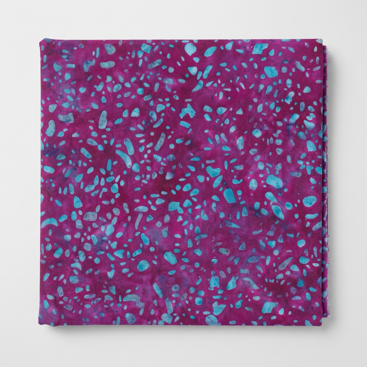 Terrazzo Purple Haze Fabric by Riley Blake Designs neatly folded on a light-gray background, showing its purple-magenta and aqua-blue pebble print.