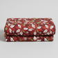 Winter Solstice II Red Poinsettia Metallic quilting cotton by Jason Yenter for In The Beginning Fabrics — folded fabric bolt showing kaleidoscopic poinsettia pinwheels in deep red, white, and forest green on rich burgundy with scattered white snowflakes and gold metallic berry sprigs, 100% cotton with metallic accents, 43–44" wide. Quilt blocks shown for inspiration. Coordinating fabrics and quilt patterns are available at IraRobi Quilts.