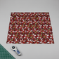 Winter Solstice II Red Poinsettia Metallic quilting cotton by Jason Yenter for In The Beginning Fabrics — fabric laid flat showing dramatic kaleidoscopic poinsettia print in deep red, white, and green on burgundy, shown in a clean modern quilting workspace with cutting mat and rotary cutter, 100% cotton with metallic accents. Quilt blocks shown for inspiration. Coordinating fabrics and quilt patterns are available at IraRobi Quilts.