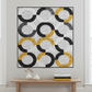 Lifestyle quilt made with Writing on the Wall and Heat Wave FreeSpirit fabrics — curved patchwork blocks in black, white, and golden yellow word art prints, displayed on wall in modern living room