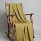 Golden Era by Paula Barnes, Wavy Daisy Green for Marcus Fabrics — sage-olive green quilting cotton with wavy daisy motif draped over a rustic rocking chair, 100% cotton 43–44" wide — IraRobi Quilts
