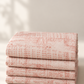 Vertical Pinterest photo of folded Celestial Stamps Text Rose Quartz fabric by Zen Chic for Moda Fabrics, with dusty-rose numbers, lettering, and grid marks on pale blush.
