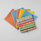 Safari Fun coordinating fat quarter bundle — Playful Strip Multi with orange triangles, blue triangles, and yellow polka dot quilting fabrics fanned on light grey background — IraRobi Quilts