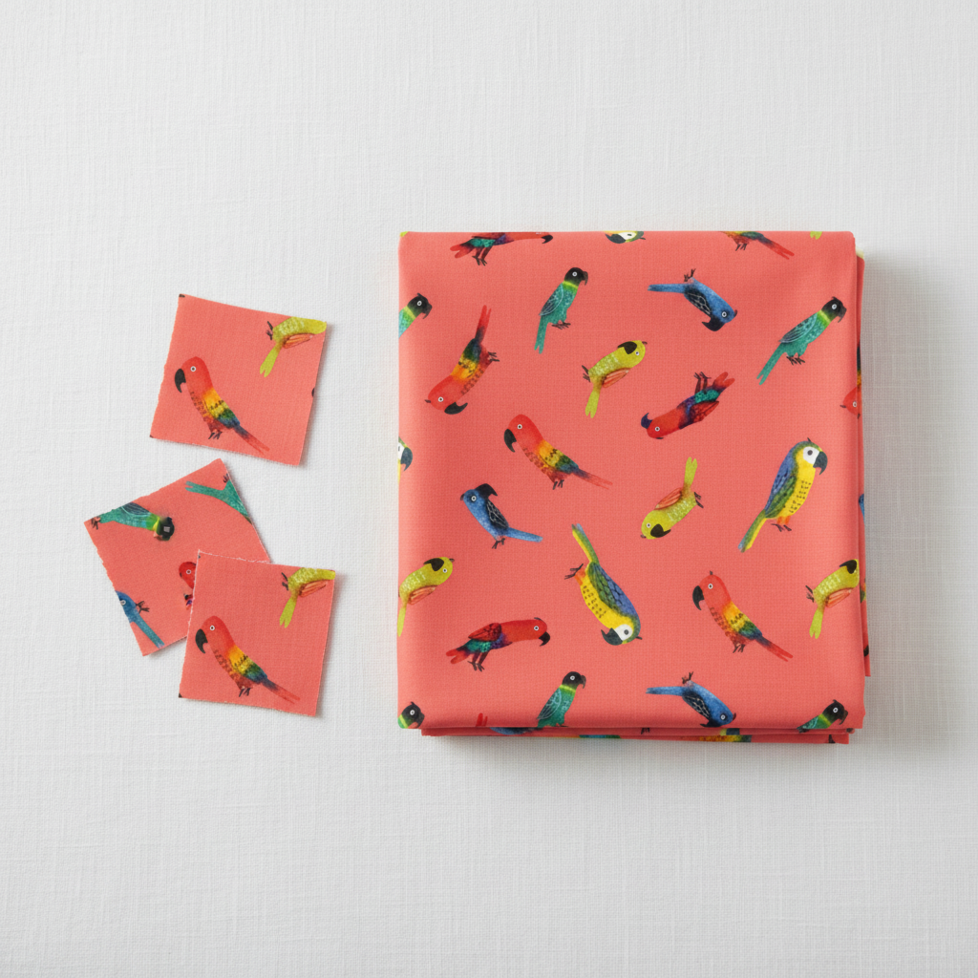 Safari Fun Jungle Birds Sorbet quilting cotton by Terry Runyan for Benartex — folded fabric bolt showing colorful tropical parrots tossed on warm coral sorbet pink, 100% cotton, 43–44" wide. Quilt blocks shown for inspiration. Coordinating fabrics and quilt patterns are available at IraRobi Quilts.