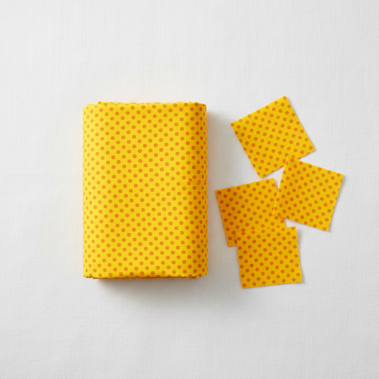 Safari Fun Random Dots Yellow/Orange quilting cotton by Terry Runyan for Benartex — folded fabric bolt showing scattered orange hand-drawn polka dots on bright sunny yellow, cheerful blender and background fabric, 100% cotton, 43–44" wide. Quilt blocks shown for inspiration. Coordinating fabrics and quilt patterns are available at IraRobi Quilts.