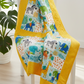 Children's quilt featuring Safari Fun Random Dots Yellow/Orange quilting cotton by Terry Runyan for Benartex as the border and sashing — bright sunny yellow with scattered orange polka dots — draped over a white chair with a monstera plant in the background. Quilts shown for inspiration. Coordinating fabrics and quilt patterns are available at IraRobi Quilts.