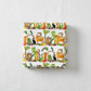 Safari Fun Stripe White/Multi quilting cotton by Terry Runyan for Benartex — folded fabric bolt showing horizontal rows of illustrated tigers, leopards, black monkeys, toucans, and parrots standing on colorful geometric blocks with palm trees and tropical leaves on white, stripe runs parallel to selvage, 100% cotton, 43–44" wide. Quilt blocks shown for inspiration. Coordinating fabrics and quilt patterns are available at IraRobi Quilts.