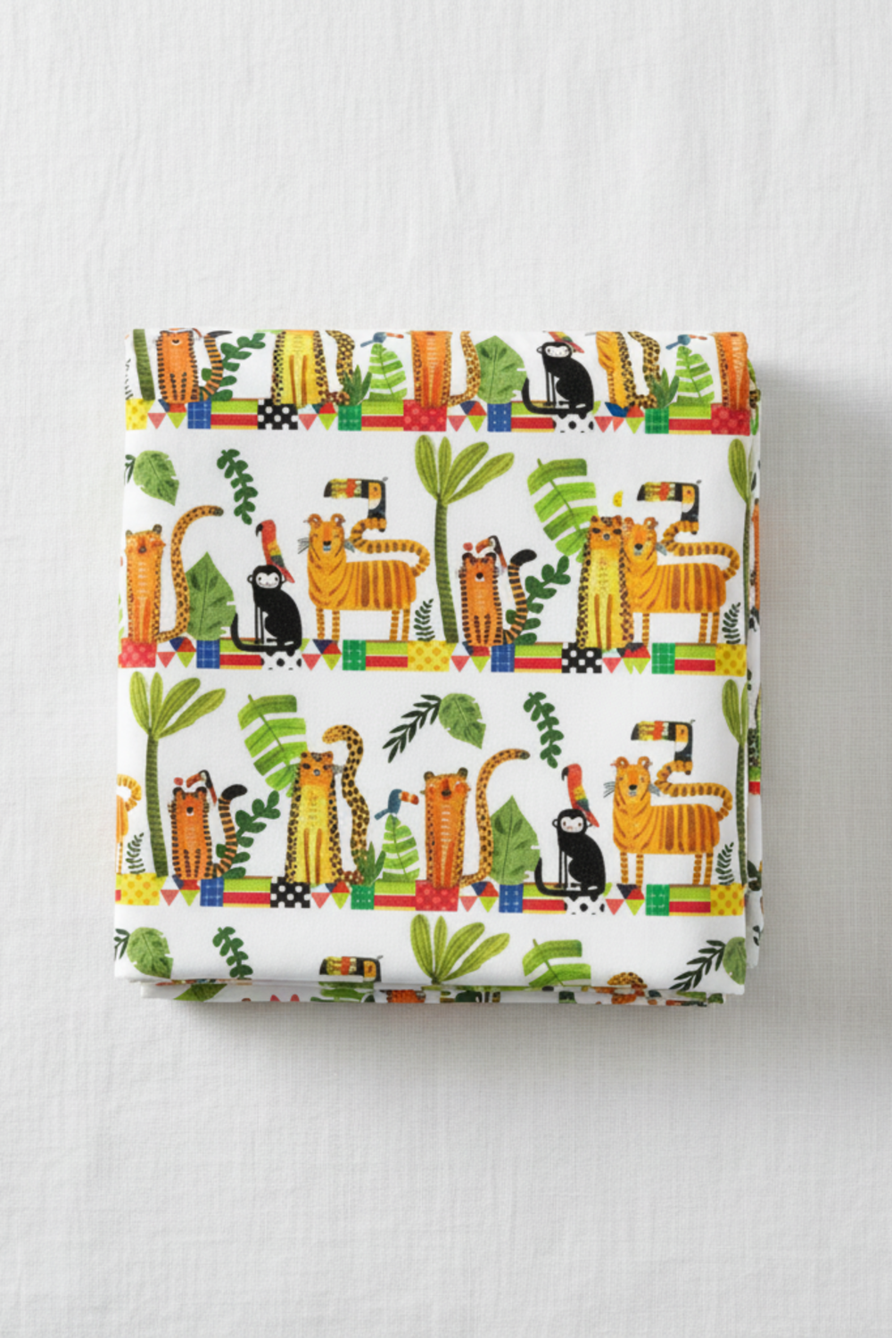Safari Fun Stripe White/Multi quilting cotton by Terry Runyan for Benartex — folded fabric bolt showing horizontal rows of illustrated tigers, leopards, black monkeys, toucans, and parrots standing on colorful geometric blocks with palm trees and tropical leaves on white, stripe runs parallel to selvage, 100% cotton, 43–44" wide. Quilt blocks shown for inspiration. Coordinating fabrics and quilt patterns are available at IraRobi Quilts.