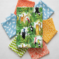 Safari Fun White/Multi quilting cotton by Terry Runyan for Benartex — crisp white with large-scale watercolor jungle animals and tropical foliage — shown with coordinating prints in sky blue, orange triangles, coral sorbet, lime green, and yellow orange dots. Quilt blocks shown for inspiration. Coordinating fabrics and quilt patterns are available at IraRobi Quilts.