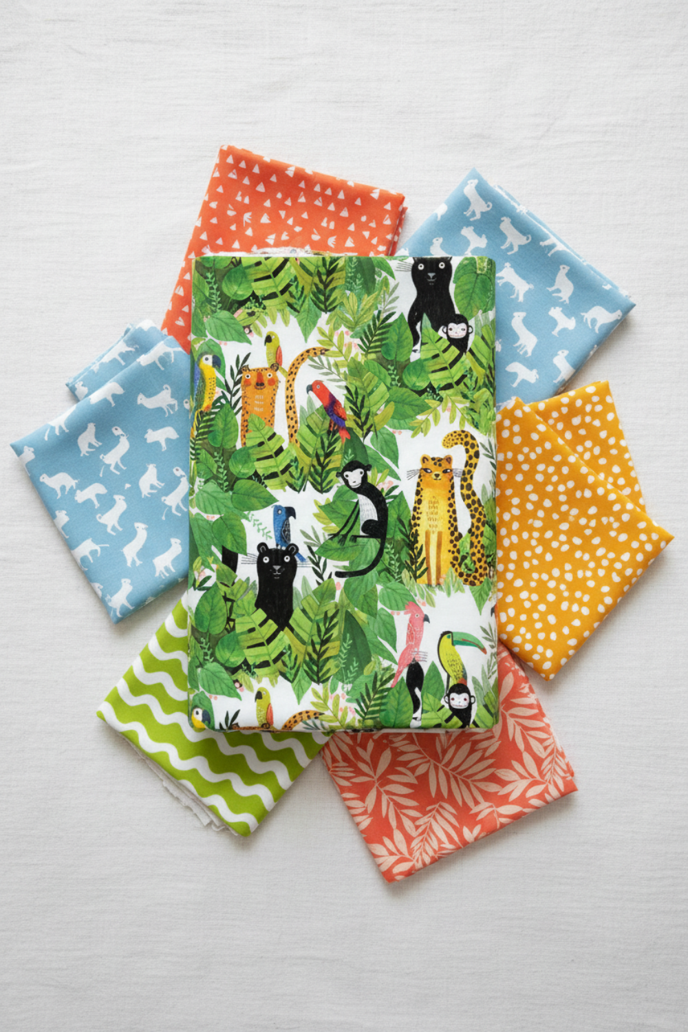 Safari Fun White/Multi quilting cotton by Terry Runyan for Benartex — crisp white with large-scale watercolor jungle animals and tropical foliage — shown with coordinating prints in sky blue, orange triangles, coral sorbet, lime green, and yellow orange dots. Quilt blocks shown for inspiration. Coordinating fabrics and quilt patterns are available at IraRobi Quilts.