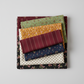 Scraps of Kindness collection coordinating fabric stack — aqua vine print with mustard, burgundy, navy, cream, and black quilting cottons