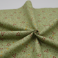 Scraps of Kindness quilting cotton in soft natural folds close-up — aqua with curling vine and red star clusters, emphasizing fabric drape and texture, by Kim Diehl for Henry Glass
