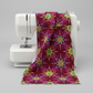 What If Radio Star Red/Multi fabric draped over sewing machine showing natural drape and body — bold magenta and crimson starburst quilting cotton by Paula Nadelstern for Benartex