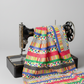 Multicolor strip print quilting cotton draped over a vintage black Singer sewing machine — Safari Fun Playful Strip Multi by Terry Runyan for Benartex — IraRobi Quilts
