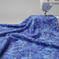 Fire & Ice by Maywood Studio Navy Ice Dye cotton quilting fabric draped over a sewing machine table on light grey background