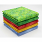 Expressions Batiks Hand-Dyes Shamrock fabric by Riley Blake Designs on top of a coordinating stack of five Expressions Batiks Hand-Dyes tonal batik fabrics – bright electric lime-green on top with forest green, tomato red, curry yellow, and periwinkle blue tonal batiks below, 100% cotton