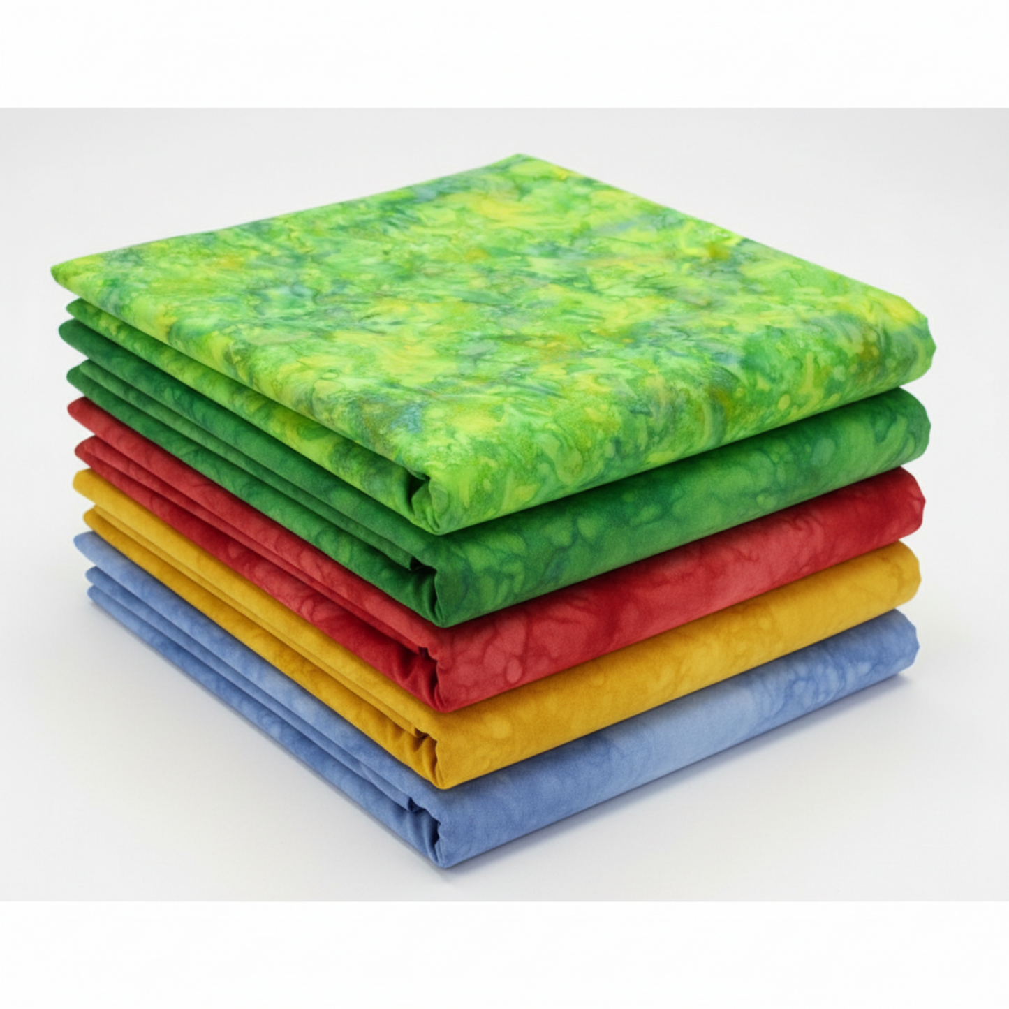 Expressions Batiks Hand-Dyes Shamrock fabric by Riley Blake Designs on top of a coordinating stack of five Expressions Batiks Hand-Dyes tonal batik fabrics – bright electric lime-green on top with forest green, tomato red, curry yellow, and periwinkle blue tonal batiks below, 100% cotton