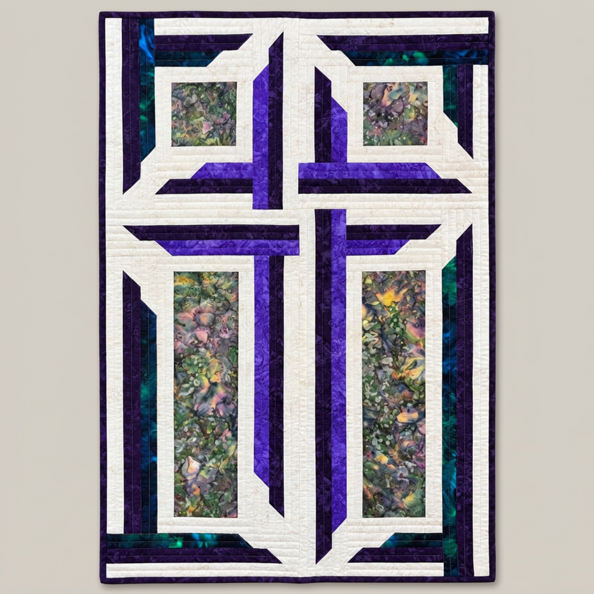 The Wondrous Cross quilted wall hanging shown against light grey, featuring a white cross framed by purple, teal, and floral batik patchwork.