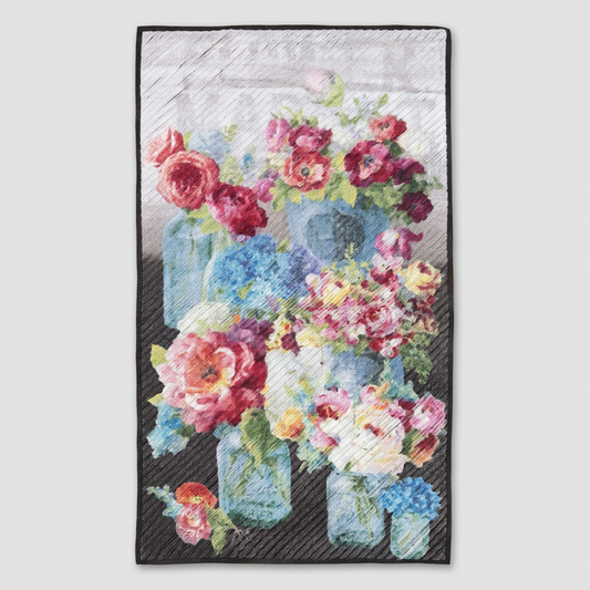 Vase with Flowers handmade wall quilt featuring pink, red, white, and blue blooms in blue glass jars, with diagonal quilting and dark binding against light grey.