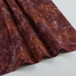 Poppy Seeds Raisin Fabric by Riley Blake Designs draped in soft folds on a light-gray background, showing its rust-brown and plum botanical print.