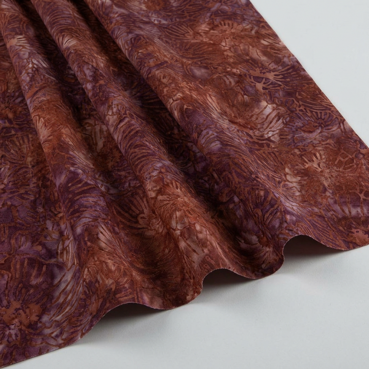 Poppy Seeds Raisin Fabric by Riley Blake Designs draped in soft folds on a light-gray background, showing its rust-brown and plum botanical print.