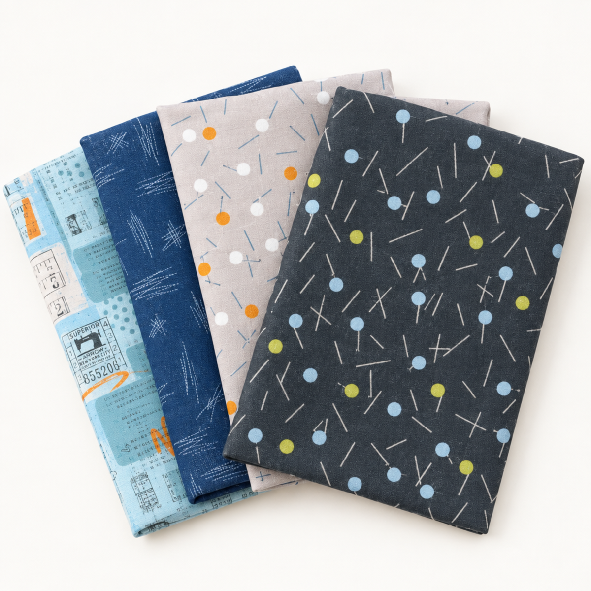 Fanned arrangement of coordinating Bluish fabrics in pale blue, blueprint blue, gray, and charcoal by Zen Chic for Moda Fabrics.