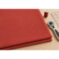 Folded Breezeway Medium Red Palm Patterns fabric on a sewing table beside a rotary cutter, quilting ruler, and red thread.