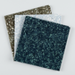 Terrazzo Smoky Teal batik fabric by Riley Blake Designs fanned in front of coordinating pale blue-gray and khaki speckled fabrics on a light gray background.