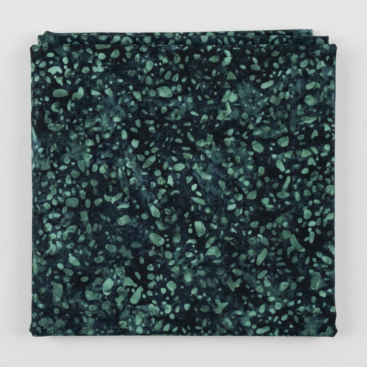 Folded Terrazzo Smoky Teal batik fabric by Riley Blake Designs, showing soft teal terrazzo speckles on a dark navy-teal ground against a light gray background.