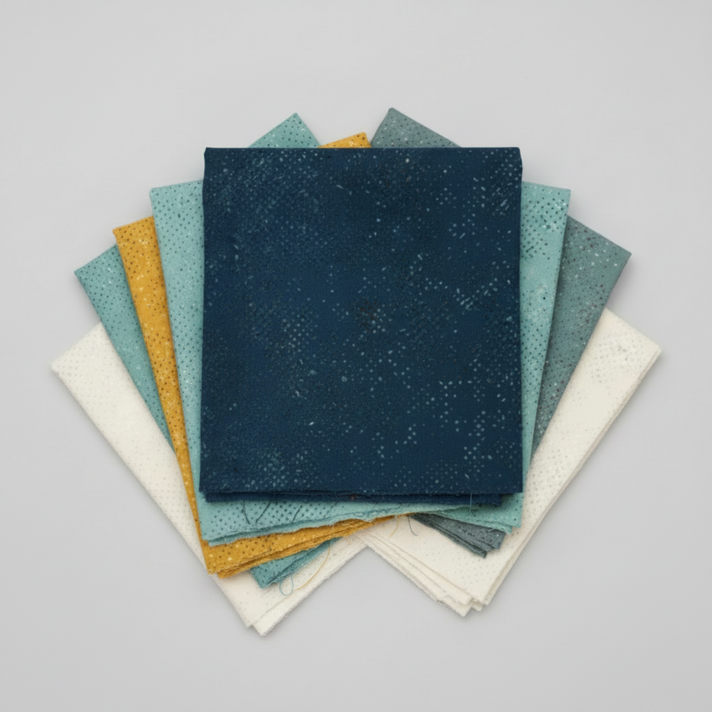 Spotted Mood Dark Blue fabric by Zen Chic for Moda Fabrics shown in a coordinating fabric fan with Spotted Chill-Aqua, Spotted Dusty Teal, Spotted Sunny, and Spotted Ivory — all available at IraRobi Quilts.