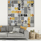 Spotted Geese flying geese quilt made with Interwoven Slate as light background and Charcoal, Espresso, Butterscotch and Pumpkin geese, hung above a grey sofa in a modern Scandinavian living room – Interwoven Slate fabric by Jason Yenter for In The Beginning Fabrics, available at IraRobi Quilts