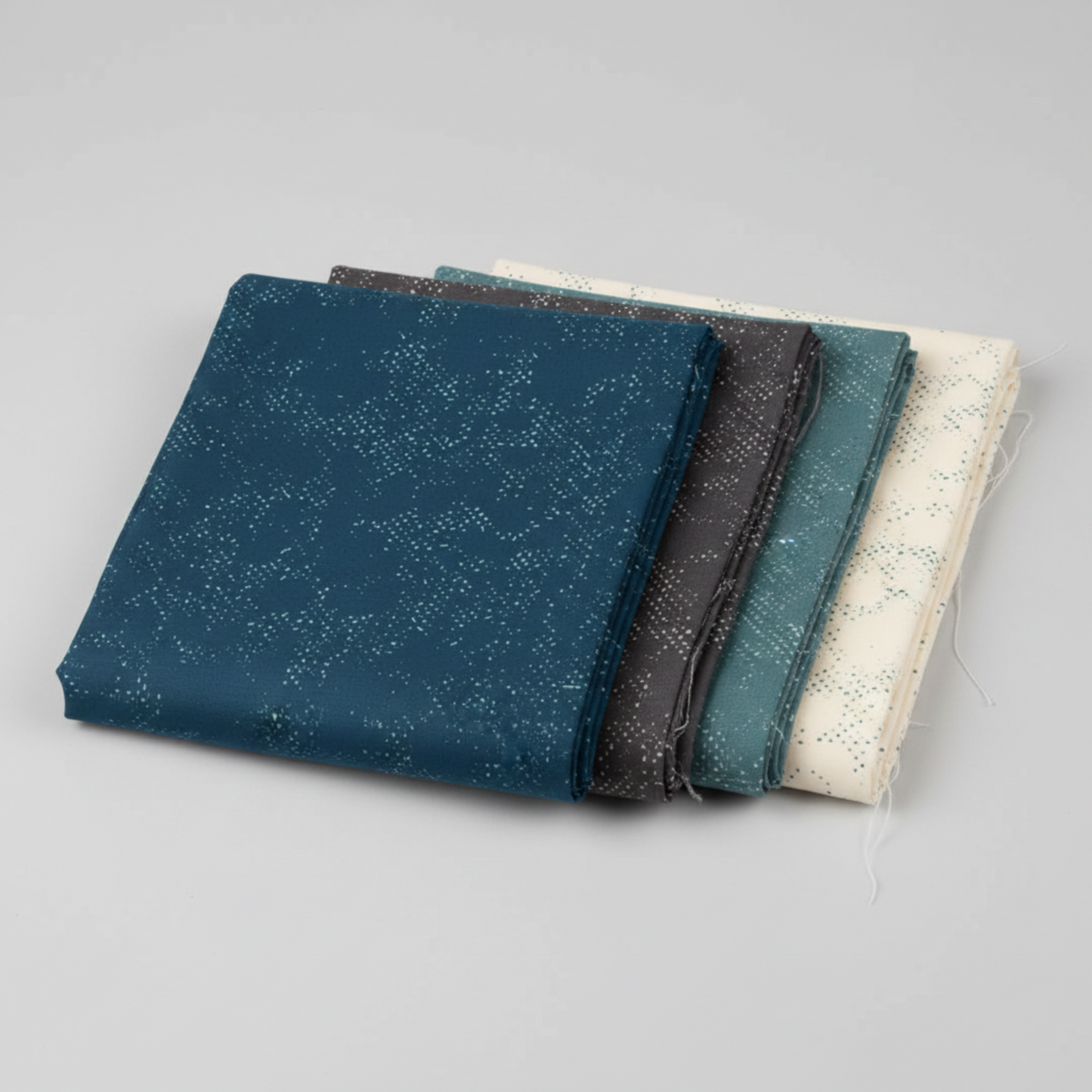 Spotted Mood Dark Blue fabric by Zen Chic for Moda Fabrics shown in a coordinating fabric fan with Spotted Chill-Aqua, Spotted Dusty Teal, Spotted Sunny, and Spotted Ivory — all available at IraRobi Quilts.