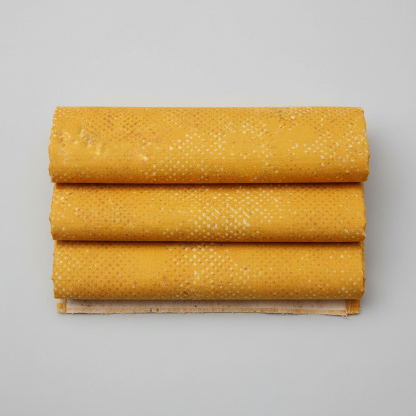 Spotted Sunny golden amber-yellow quilting cotton fabric folded to show texture – tonal scattered dot blender by Zen Chic for Moda Fabrics, 100% cotton
