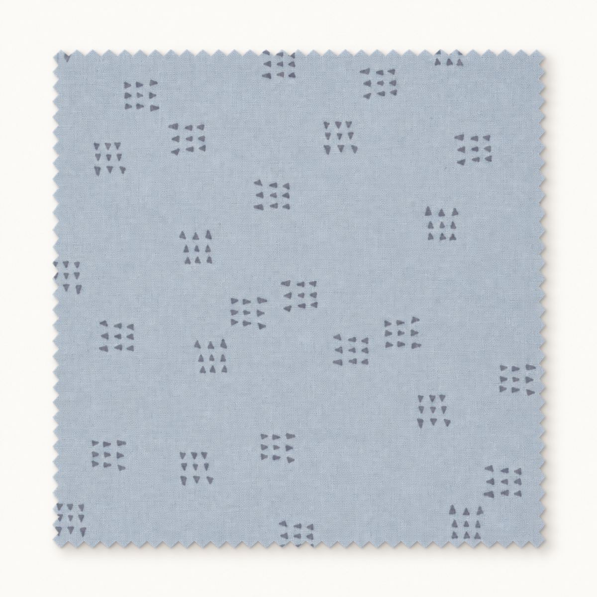 Square swatch of Celestial Nine Triangle Stardust fabric by Zen Chic for Moda Fabrics, featuring scattered charcoal triangle clusters on pale blue-gray.