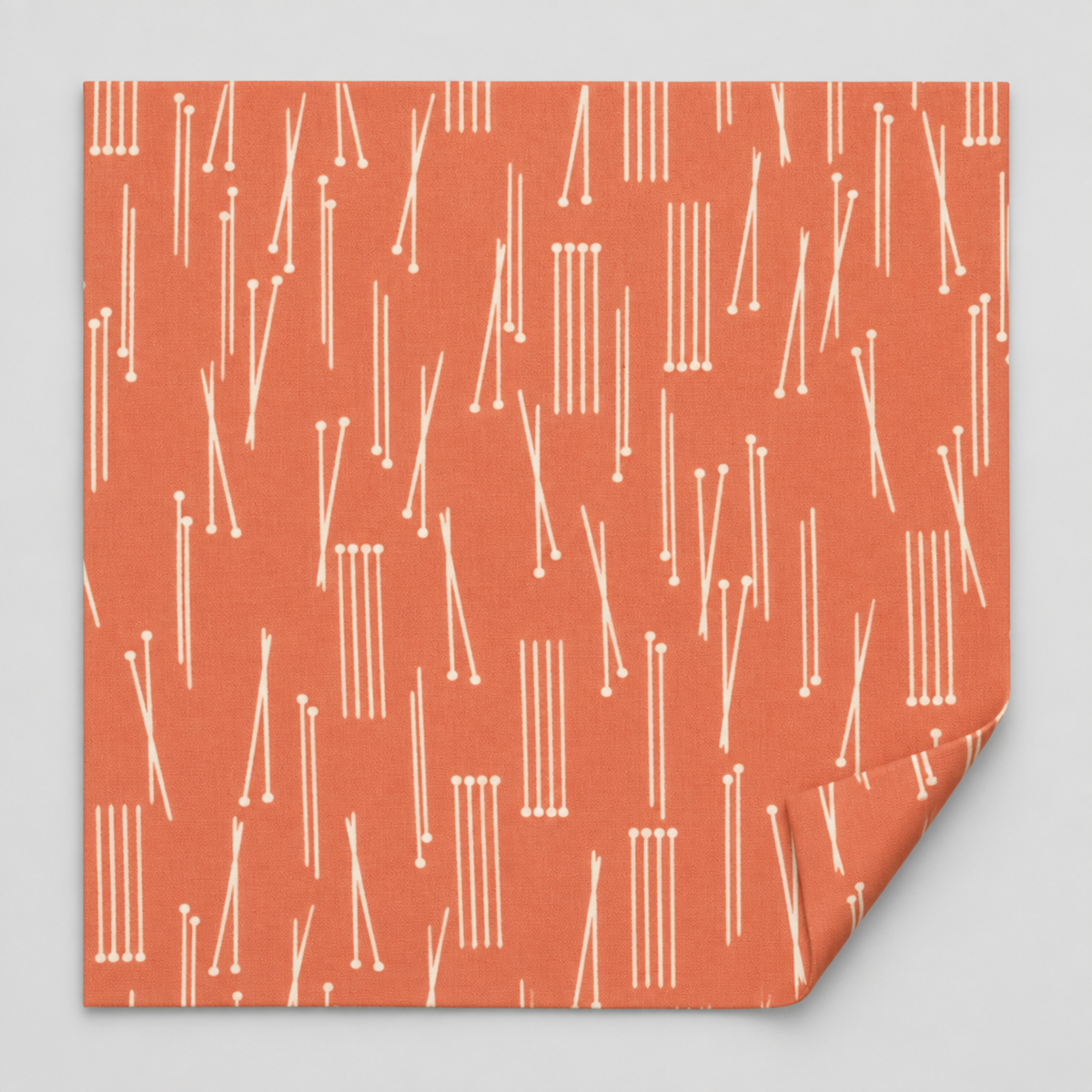 Lazy Afternoon Marmalade fabric laid flat with one corner folded back, showing its cream linear print on a coral ground.