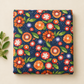 Folded Superbloom Posy Party Indigo fabric by Robin Pickens for Moda Fabrics, styled on a cream surface beside a leafy green sprig.