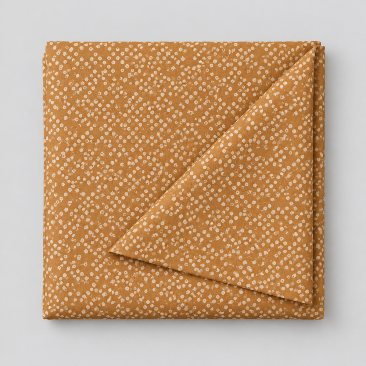 Lazy Afternoon Bronze fabric folded with one corner turned back, showing the pale dotted print on a warm bronze ground.