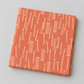 Folded Lazy Afternoon Marmalade fabric showing the fine cream linear print on a coral ground.