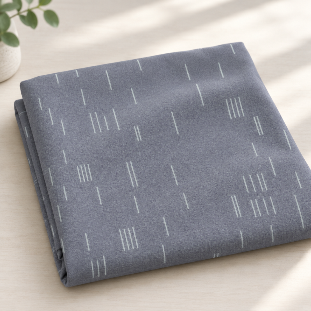 Folded Celestial Strokes Aluminum fabric by Zen Chic for Moda Fabrics displayed in soft natural light.