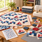 Breezeway fabrics arranged beside an unfinished Sailing School quilt project, sewing machine, and quilting tools. Quilts shown for inspiration feature the Sailing School by Joanne Kerton of Canuck Quilter Designs — all available at IraRobi Quilts.s photo