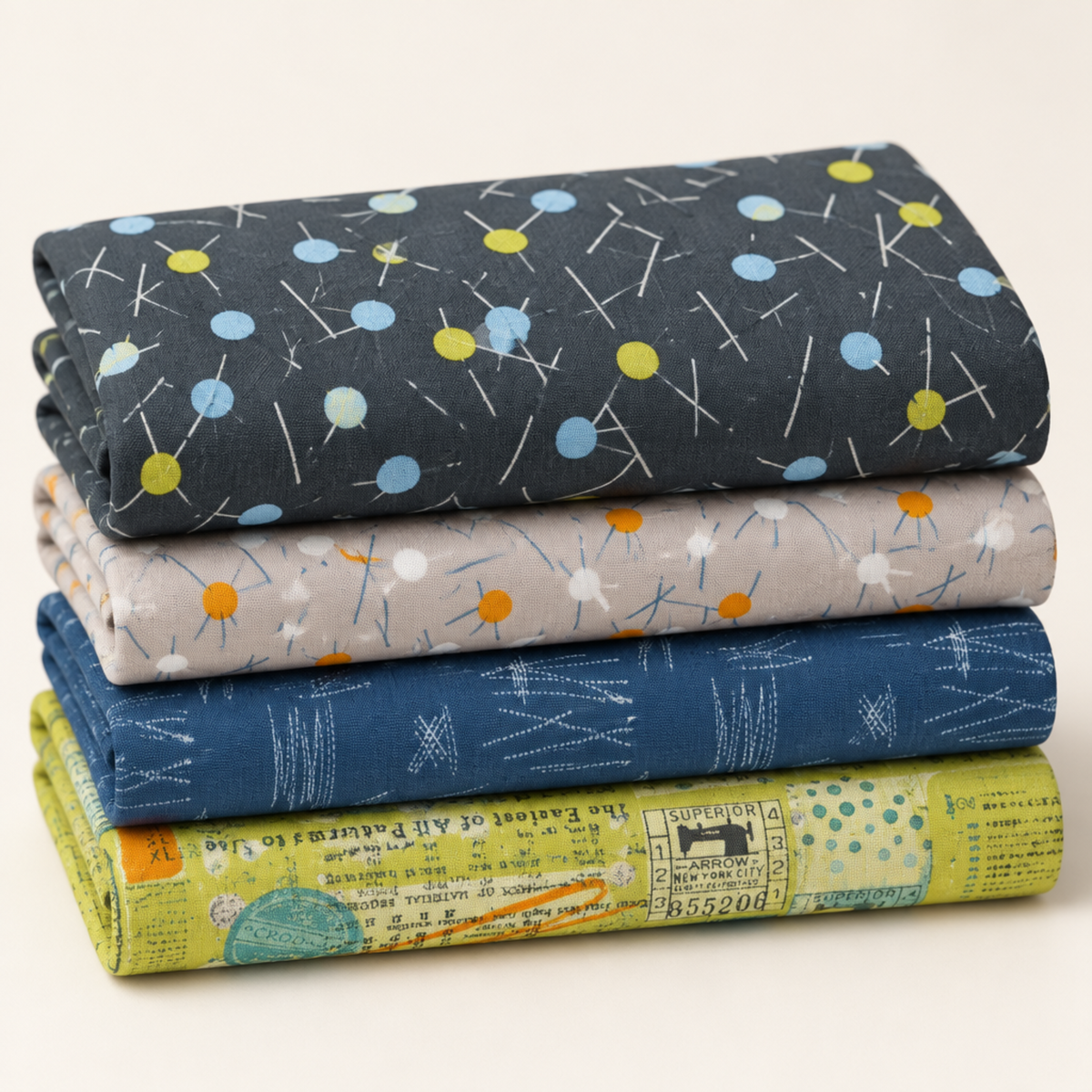 Folded stack of coordinating modern quilting fabrics in charcoal, gray, blue, and chartreuse, topped with Bluish Pins & Buttons Charcoal.